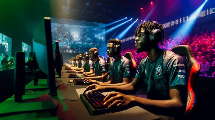 A team of Nigerian gamers in jerseys competing at an esports tournament, focused on their screens as a large audience watches in the background.